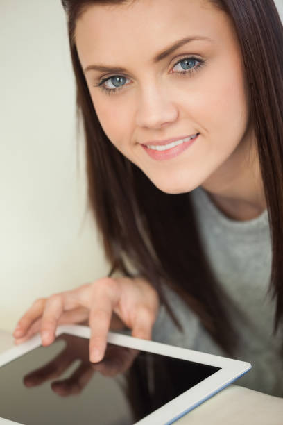 istock Smiling pretty girl using a tablet pc on a sofa looking at camera 844105838