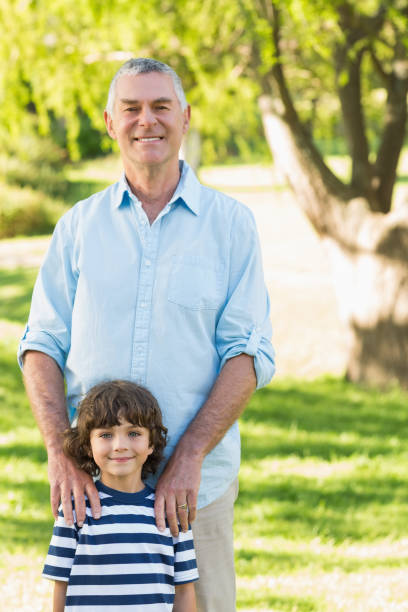 istock Grandfather and son standing at park 844110220