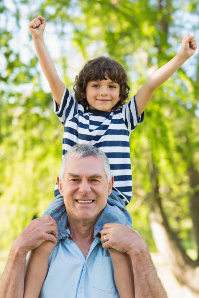 istock Grandfather carrying son on shoulders at park 844110252
