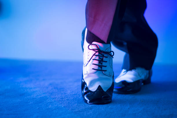 ballerino di latino maschile e salsa in scarpe da ballo jazz in bianco e nero in chiaro e buio sul palco - dance shoes foto e immagini stock