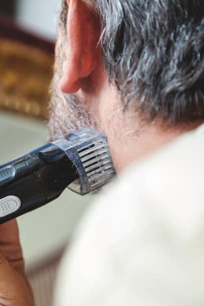 istock Grooming beard with gray hair trimmer closeup 844118068