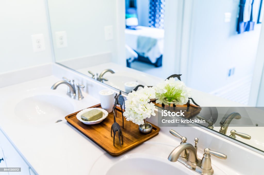 Closeup of modern bathroom his and her sinks with white countertop and mirror in staging model home, house or apartment Bathroom Stock Photo