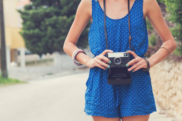 istock Young female holding a retro-styled camera outdoors. 844133406