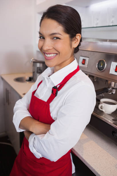 istock Pretty young barista leaning against counter smiling at camera 844144012