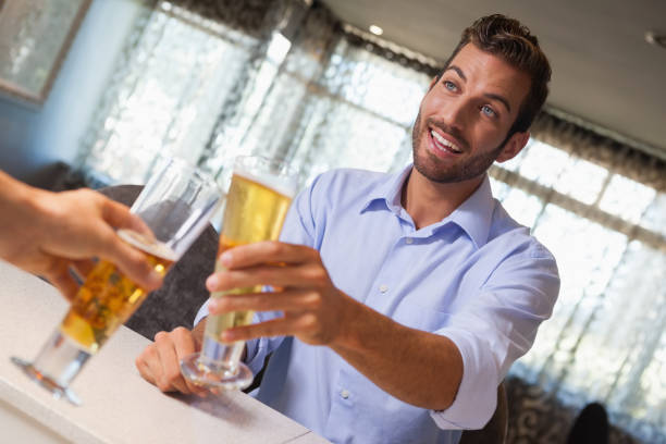 istock Smiling businessman clinking glass of beer with bartender 844144920