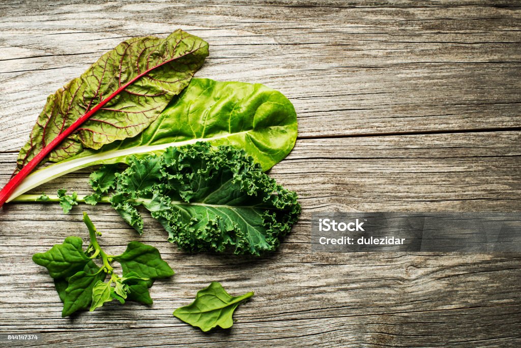 vegetable leaves of salad Vegetable healthy green leaves. Kale, swiss chard and spinach on wooden background Kale Stock Photo