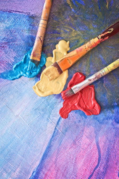 istock Brushes and colors on painted canvas 844156504