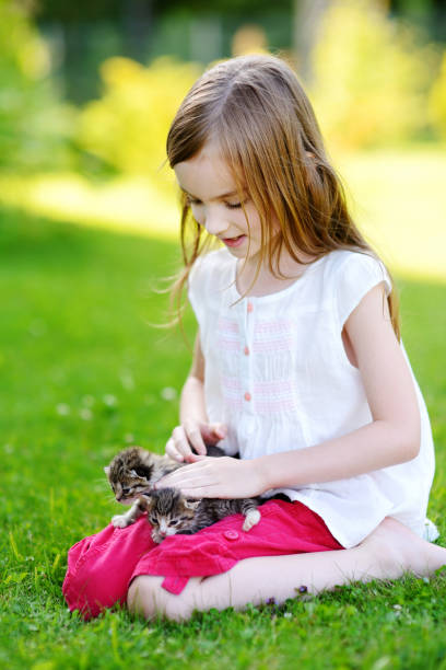 istock Adorable little girl playing with small kittens 844160392
