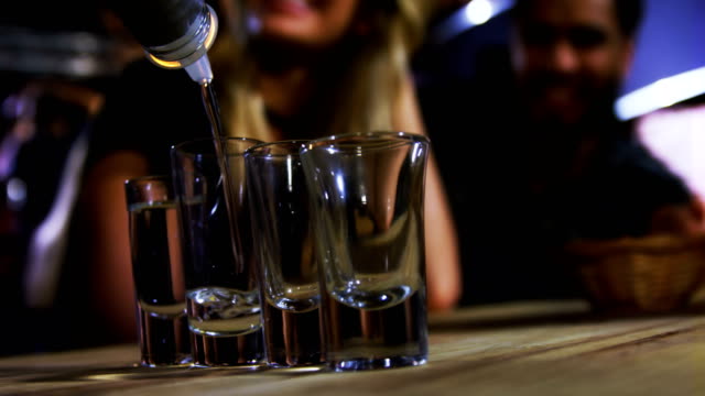 Bartender tequila in shot glasses in bar