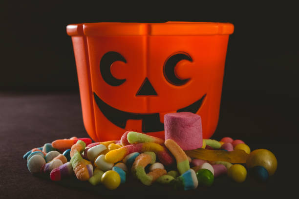 istock Orange bucket with various candies over black background 844167428