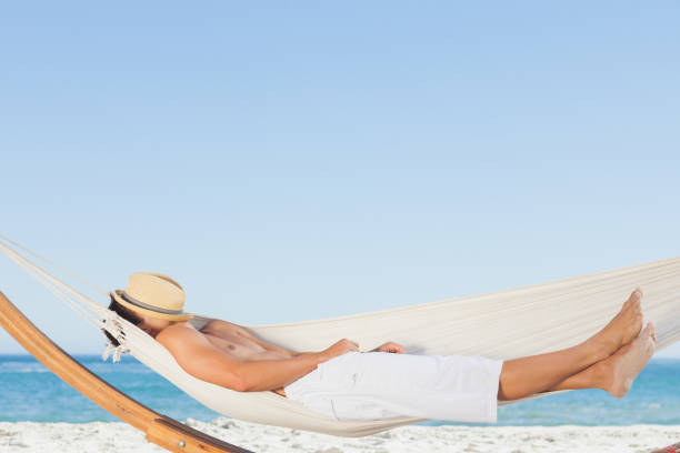 istock Man wearing straw hat relaxing in a hammock 844167586