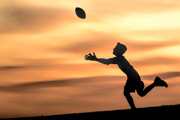 istock Silhouette of boy going to catch the ball. 844174154