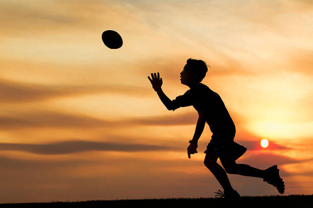 istock Silhouette of boy playing ball at sunset. 844174172