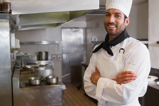 istock Happy head chef smiling at camera with arms crossed 844174360