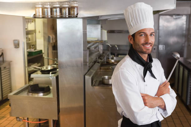 istock Happy chef looking at camera with arms crossed holding ladle 844174450