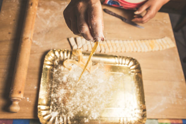 Homemade Tagliatelle. Pasta Preparation on the Wooden Table with Female Hands.