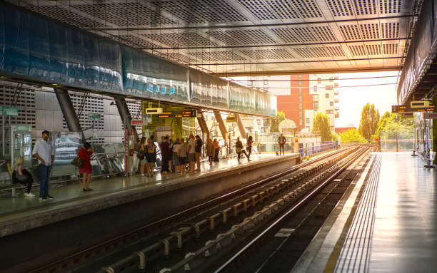 stazione dlr canary wharf e persone sulla piattaforma contro la luce del sole - docklands light railway foto e immagini stock