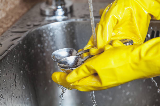 istock Hands in yellow rubber gloves wash teaspoons 844180146