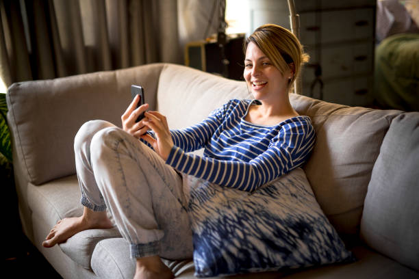 istock woman sitting on the couch take some good time with cellphone 844183064