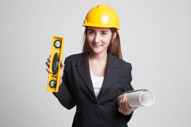 istock Asian engineer woman with blueprints and level. 844183740