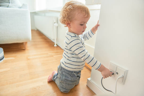 istock Baby boy touching electrical plug in the wall. 844189438