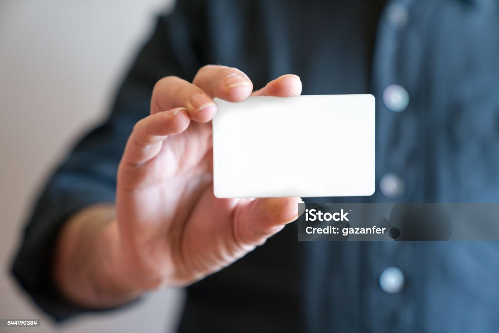 Hand holding blank white credit card mockup front side view. Plastic bank-card design mock up Playing Card Stock Photo