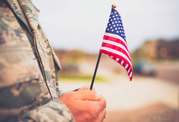 amerykański żołnierz wojskowy z flagą. motyw patriotyczny - us veterans day zdjęcia i obrazy z banku zdjęć