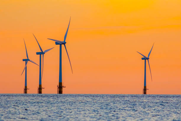 Offshore wind farm energy turbines at dawn. Surreal but natural sunrise at sea. Offshore wind farm energy turbines at dawn. Surreal but natural sunrise at sea. Modernistic image. The future of clean energy production. offshore wind farm stock pictures, royalty-free photos & images