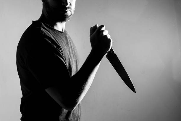 istock Man in black t-shirt, standing holding a knife. 844199058