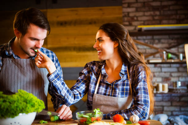 istock Young man and woman cooking and eating together at kitchen 844199464
