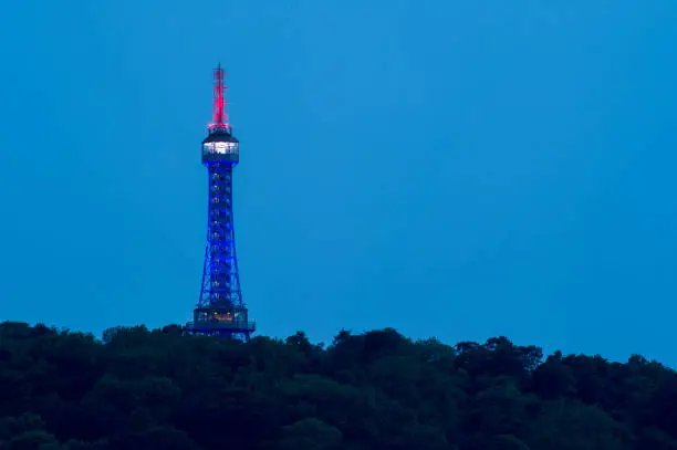 Petrin lightup lookout tower in Prague at blue hour. Lighting in British tricolor, red, blue and white light.