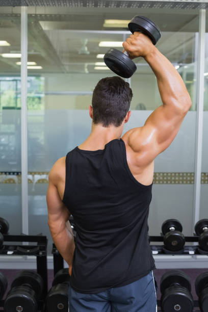 istock Rear view of a muscular man exercising with dumbbell 844209934