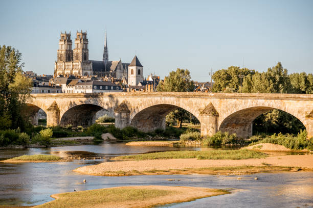 Orleans city in France Landscape view on the river and old arch bridge in Orleans city during the sunset in France orleans france photos stock pictures, royalty-free photos & images