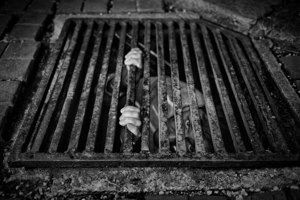 istock man looking afraid out of manhole at night 844220308
