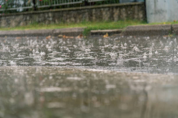 istock heavy rain drops falling on city asphalt during downpour 844222860