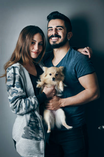 istock Smiling young man and woman hugging a dog 844223700