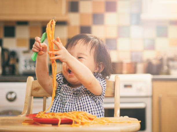 istock baby girl eating messy spaghetti 844229804