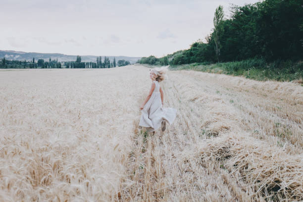 istock Girl runs along a wheat field. 844233542