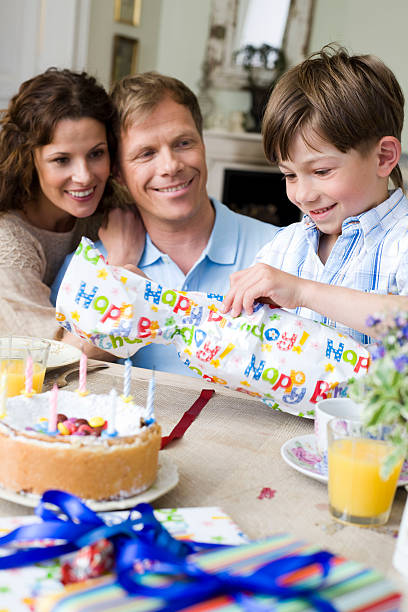 menino abrindo seu presente de aniversário "munique, alemanha" - birthday cake family germany indoors - fotografias e filmes do acervo