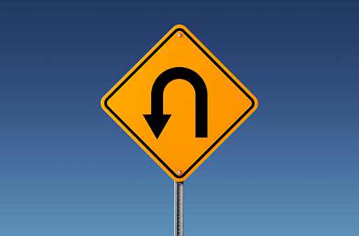 Yellow u turn sign on blue sky. U Turn Concept. Horizontal composition with copy space. Clipping path is included.