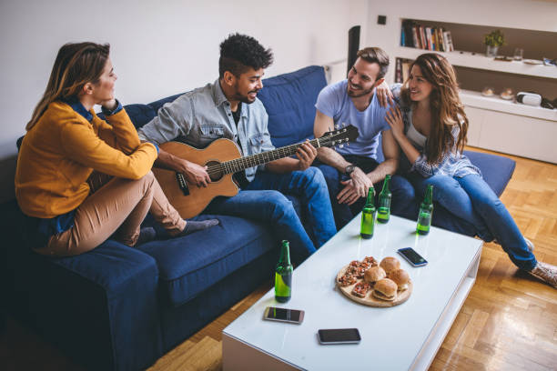istock Group of friends having fun drinking beer and playing guitar 844249532