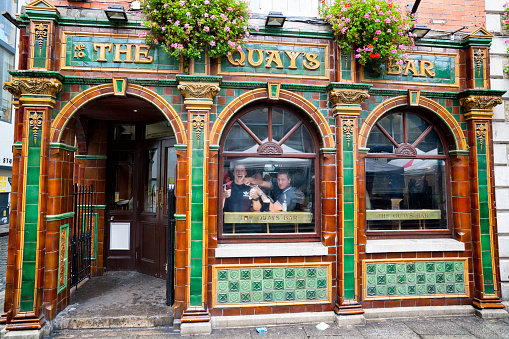 Dublin, Ireland - May 21, 2016. Two men enjoying a pint at the The Quays Bar in Temple Bar district of downtown Dublin the capital of Ireland. The area has a lively nightlife and is very busy with people most of the day.