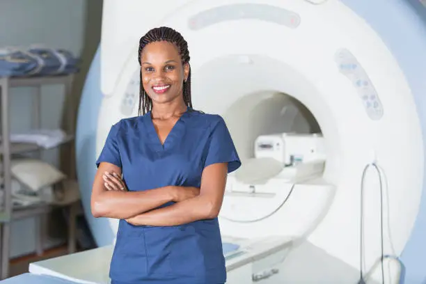 Photo of Technician standing in front of MRI scanner