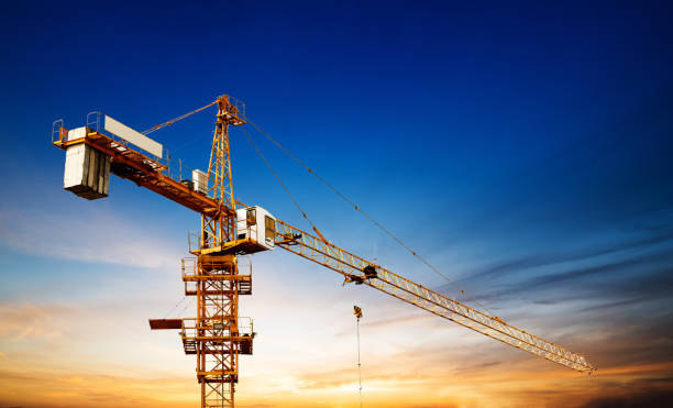 istock Industrial construction cranes and building silhouettes over sun at sunrise. 844277792
