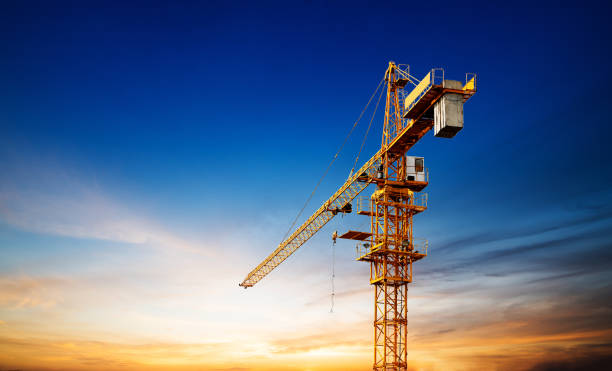 istock Industrial construction cranes and building silhouettes over sun at sunrise. 844277880