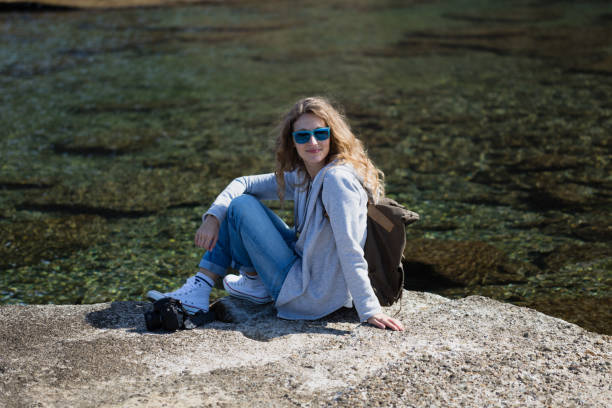 istock Woman tourist with camera and backpack sitting and relaxing 844278442