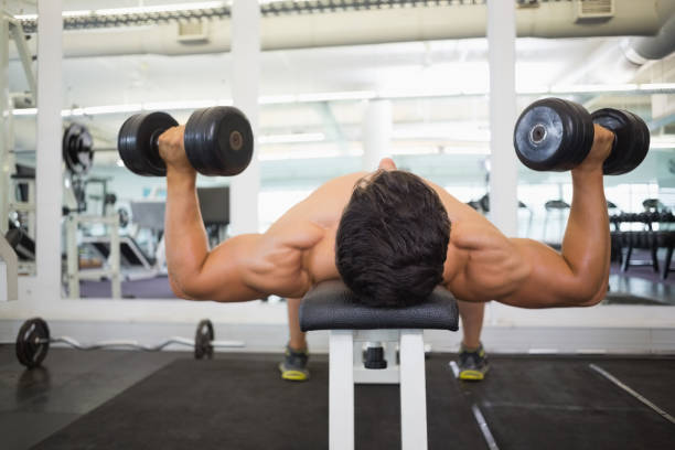 istock Muscular man exercising with dumbbells in gym 844281966