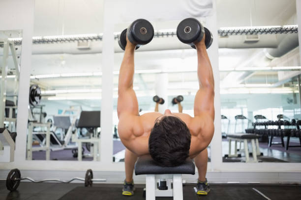 istock Muscular man exercising with dumbbells in gym 844282046