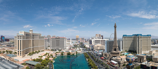Daytime high-angle view of the Las Vegas strip featuring the Eiffel tower replica and the fountains of Bellagio as well as the resort hotels Bellagio, Paris-Las Vegas, Ballys and Caesars Palace.
