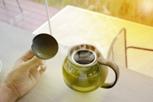 istock hot tea pot with smoke on wooden table 844297376